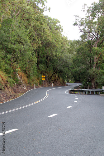 Winding road of the Gillies Highway in Far North Queensland, Australia, surrounded by trees photo