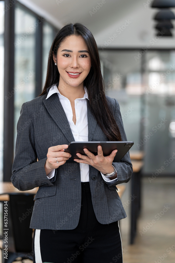 © NAMPIX - Young happy businesswoman working with tablet in corporate office © NAMPIX - Young happy businesswoman working with tablet in corporate office
