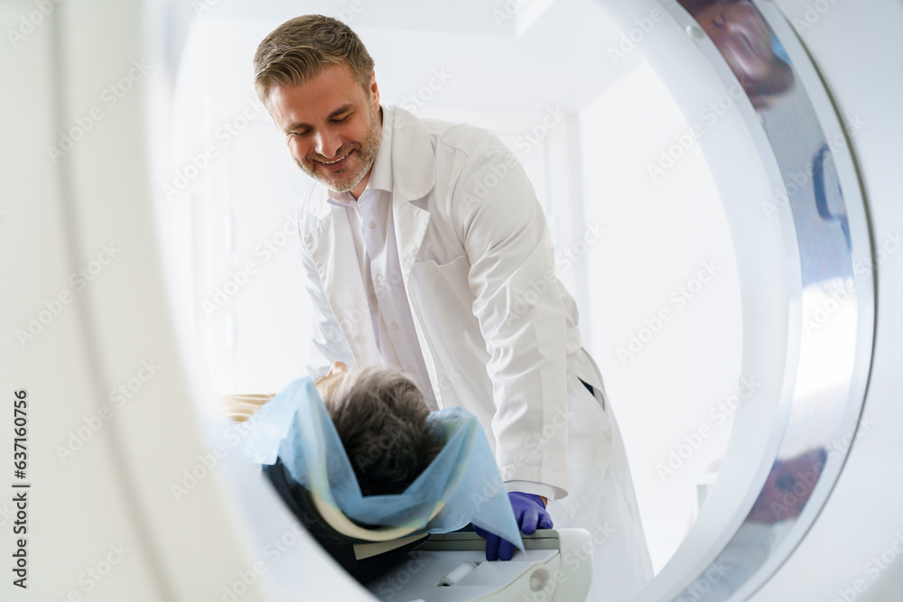 Radiologist controls MRI or CT Scan with patient undergoing procedure. High Tech medical equipment Radiologist controls MRI or CT Scan with patient undergoing procedure. High Tech medical equipment