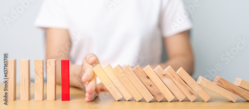 Obraz na plátně Hand stop falling wood domino blocks on table