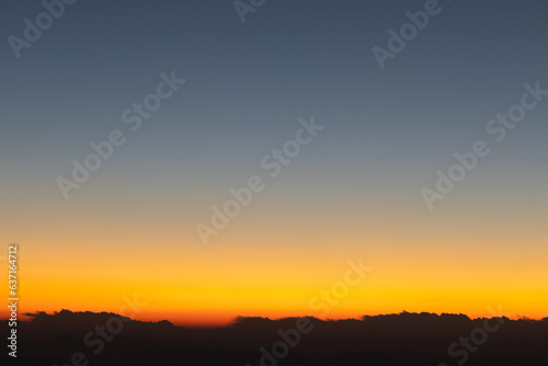 Heaven at early morning with copy space. Sunset  sunrise backdrop.Predawn clear sky with orange horizon and blue atmosphere. Smooth orange blue gradient of dawn sky.