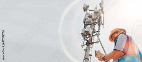 Asian male engineer safety helmet works in the field  high rise building inspecting telecommunication tower structures setting up electronic power grids and maintaining 5G networks for safety reasons. photo