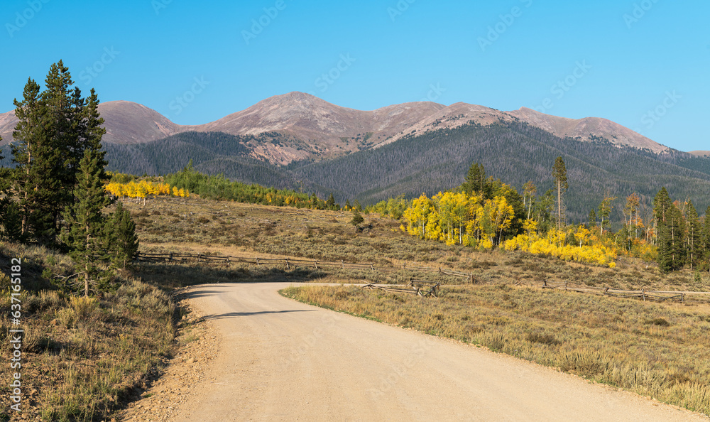 A country road leads to an autumn vista with changing leaves and the crisp air of high country of Colorado.