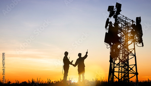 Silhouette architect electrician team in sunset Two engineers are planning to power towering outdoor telecommunication antenna tower that will improve the performance of generation 5G technology. photo