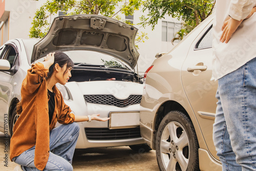 Disappointed woman watching her car get damaged due to an accident caused by a male driver carelessly shifting the reverse gear to the point of being damaged : Car Accident Insurance concept.