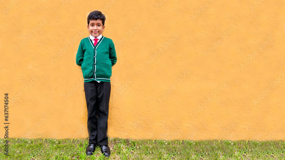 Dark-haired 9-year-old Latino boy in a public school uniform is excited and happy about the return to school ready to study