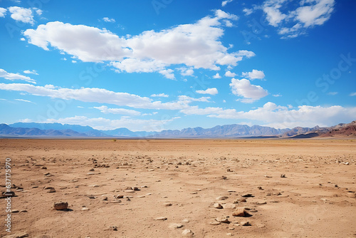 Scenic view of rugged desert landscape with arid terrain and rocky mountains under a sunny sky
