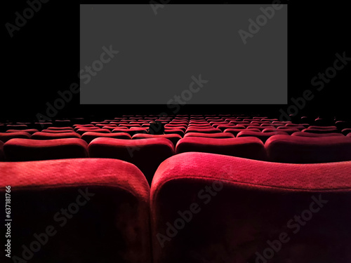 Inner view of a movie theater with rows of red audience seats.