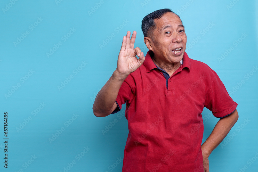 Fototapeta premium Elderly Asian man smiling and give OK hand sign