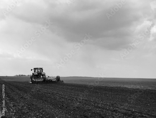 Plowed field by tractor in black soil on open countryside nature