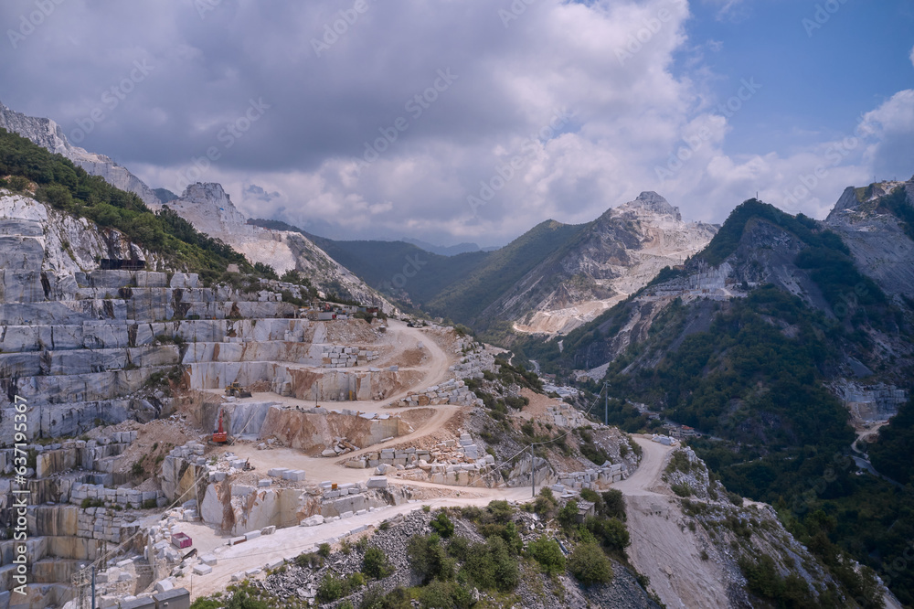 Industrial machinery in a quarry. Aerial panorama of marble quarries Carrara Italy. Marble quarry top view. Aerial panorama on the Carrara marble quarry.