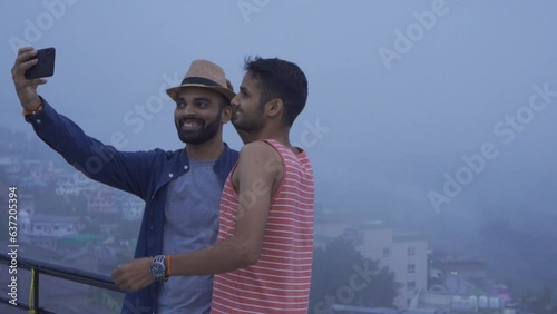  Two Freinds enjoy cloudy mountain after snowfall Almora Uttarakhand, india. photo