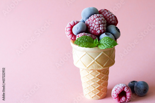 Frozen summer fruits with mint leaf in waffle on pink background, summer ice cream concept