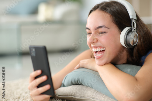 Happy woman watching videos laughing at home