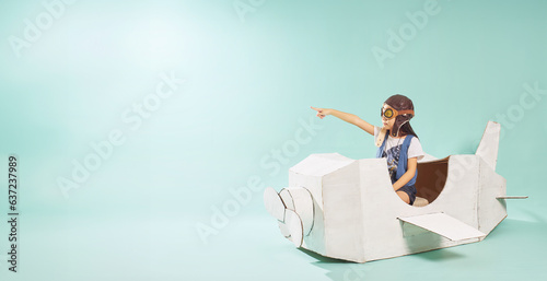 Foto Little cute girl playing with a cardboard airplane