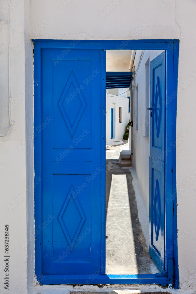 Traditional, blue wooden door of a typical house in Cyclades, half open to the patio of the house, in Koufonisi island, Cyclades, Greece, Europe