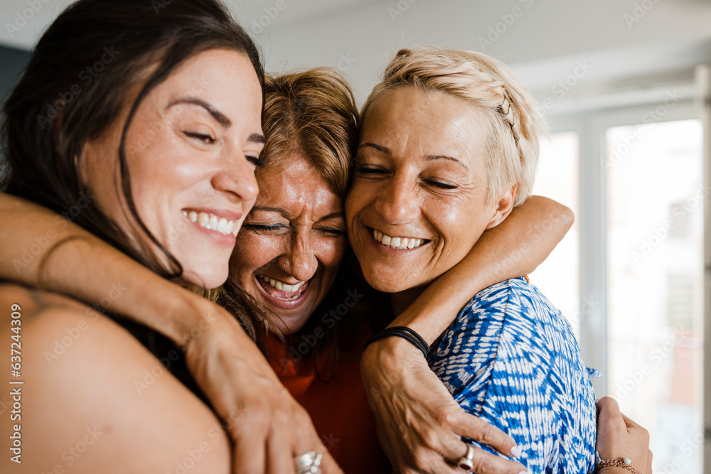 Cheerful friends hugging each other in apartment Cheerful friends hugging each other in apartment
