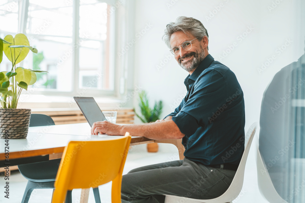Smiling businessman sitting on chair in office