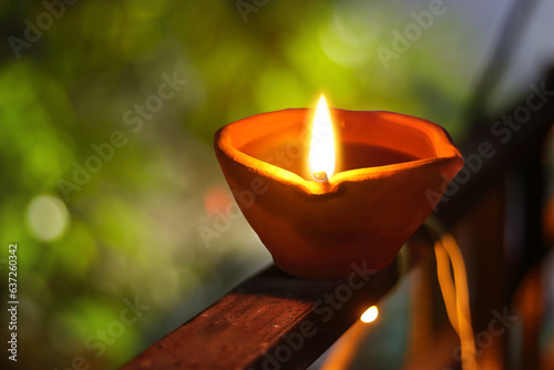 selective focus. clay diya lamps lit during diwali celebration. Lit diya lamp on street at night or beautiful diwali lighting, Traditional symbols of Indian festival of light. Burning diya oil lamps