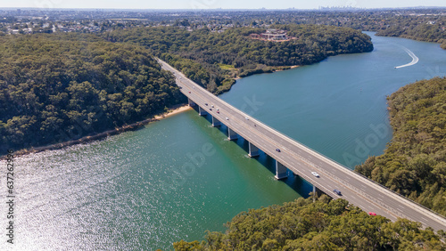 Aerial drone view rising up over Alfords Point Bridge across Georges River in Southern Sydney, New South Wales, Australia looking toward Padstow Heights 