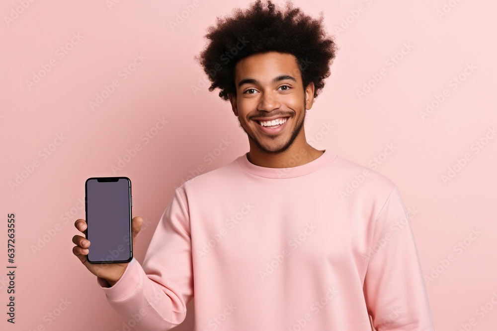 Happy African American teen student holding mobile cell phone pointing finger at smartphone mock up big screen template presenting application, using cellphone showing ad isolated on beige background. - obrazy, fototapety, plakaty 