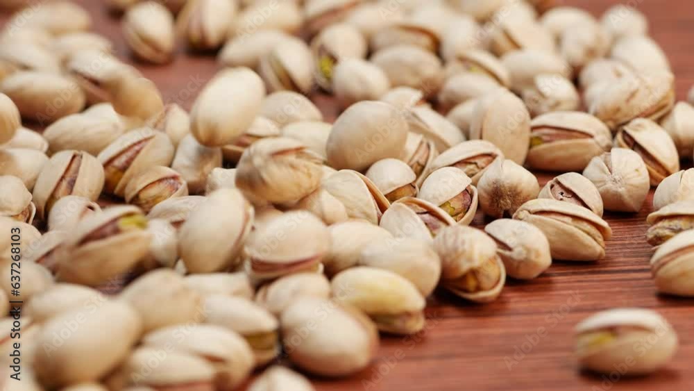A stack of pistachios on a wooden table A stack of pistachios on a wooden table