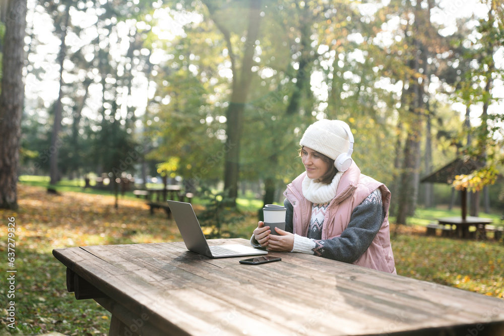 Freelancer working on laptop in autumn park Freelancer working on laptop in autumn park