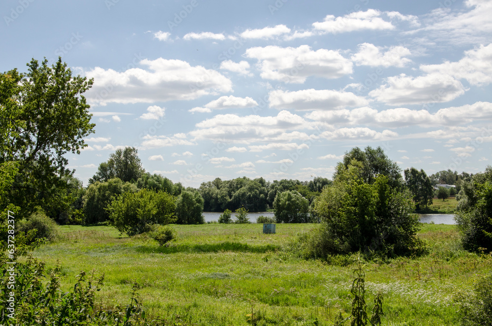 Summer landscape with river and blue sky with white clouds in sunny day Summer landscape with river and blue sky with white clouds in sunny day