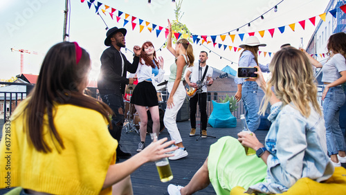 Photography Attractive smiling young carefree women drinking beer and making selfie during summer party on terrace