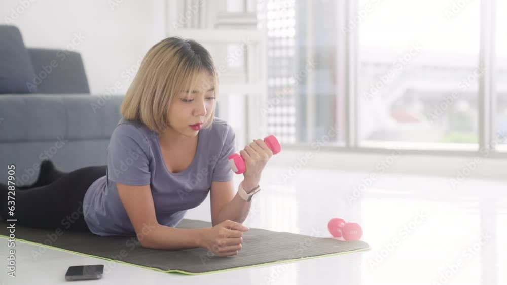Woman in activewear lying on sports mat resting after training Woman in activewear lying on sports mat resting after training