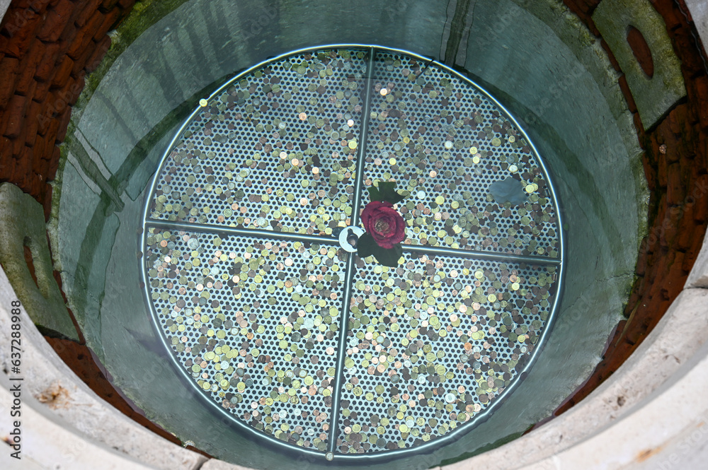 Coins in the well. A well with clean and drinking water. Money in wishing well.