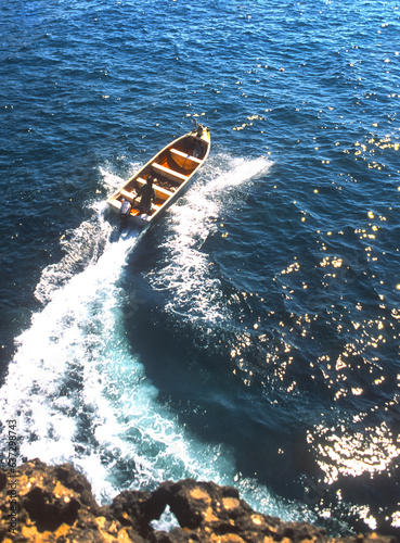 A boat speeds out to sea off the coast of Oman