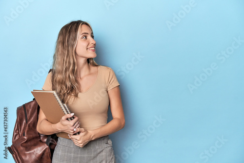 Konstfotografi Blonde student with notebooks in blue studio