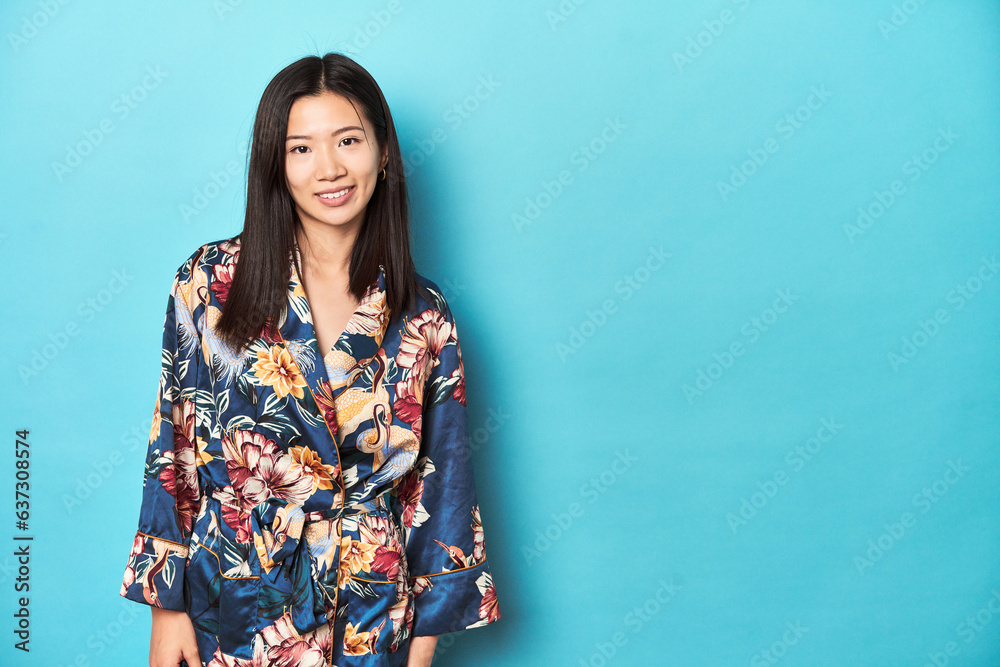 Elegant young Asian woman in floral kimono, studio backdrop. Elegant young Asian woman in floral kimono, studio backdrop.