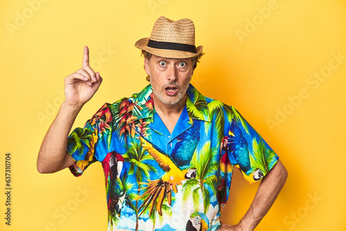 Middle-aged man in Hawaiian shirt and straw hat Middle-aged man in Hawaiian shirt and straw hathaving an idea, inspiration concept.