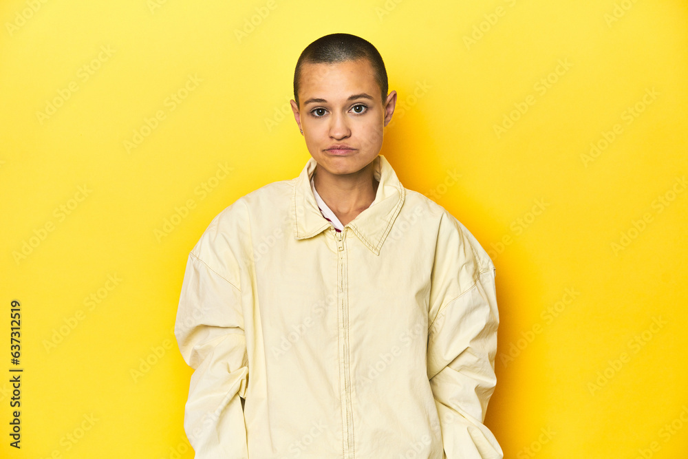 Fototapeta premium Young woman in jacket, yellow studio backdrop sad, serious face, feeling miserable and displeased.