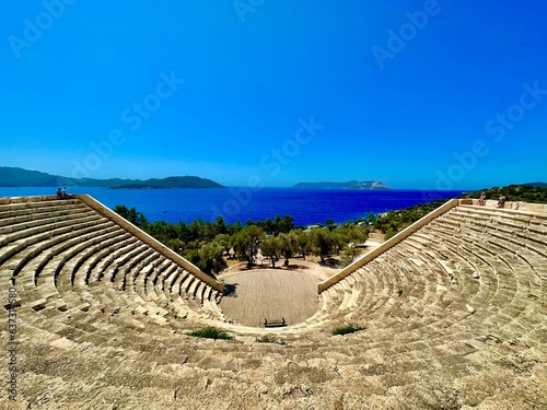 An antique amphitheater near a picturesque town with a beautiful view of the sea.