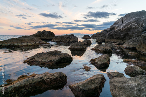 Sudak, Crimea. Bright contrasting sky after sunset. Rocks in the black sea © nikitamaykov