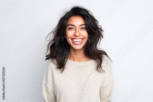 Medium shot portrait of an Indian woman in her 30s against a white background