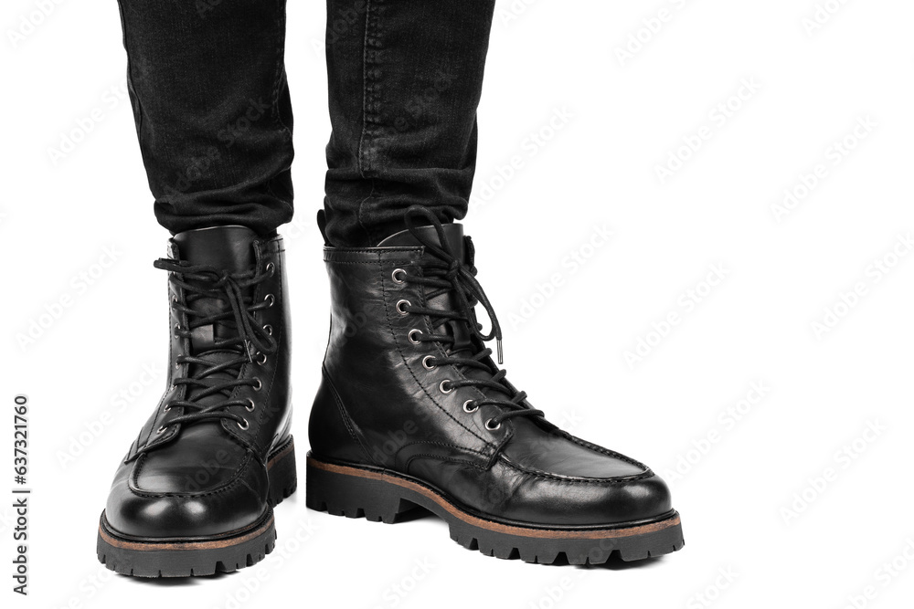 Pair of black leather boots, dress boots for men, men ankle high boots. Black brogue boots on a white background. Men fashion in leather boots. Man's legs in black jeans and brown leather boots.