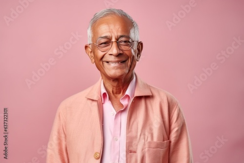 Medium shot portrait of an Indian man in his 70s in a colorful background