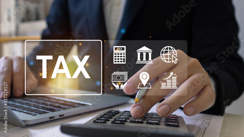 Businessman using calculator to calculate tax for Individual income tax return, building taxes ,Government taxes, state taxes, financial research, Calculation tax return form online payment.