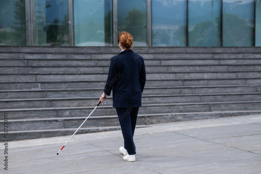 Blind businesswoman walking with tactile cane to business center. 