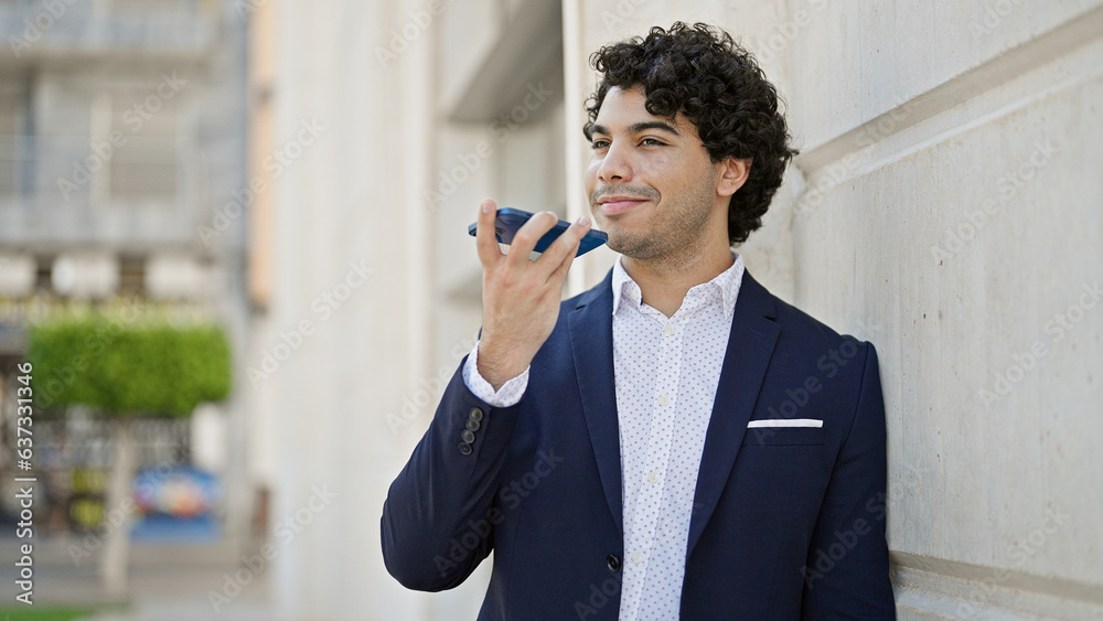 Young latin man business worker sending voice message by smartphone at street Young latin man business worker sending voice message by smartphone at street