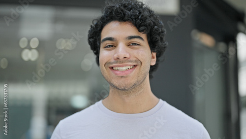 Young latin man smiling confident standing at street