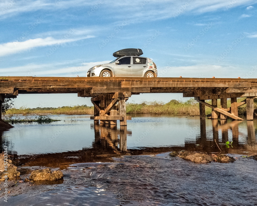 Carro cruzando ponte de madeira na Estrada pareue do pantanal em mato Grosso do sul