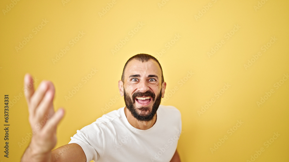 Young hispanic man smiling confident dancing over isolated yellow background Young hispanic man smiling confident dancing over isolated yellow background