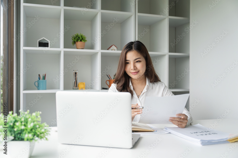 Cheerful business lady working on laptop in office, Asian happy beautiful businesswoman work in office. Attractive female employee office worker smile Cheerful business lady working on laptop in office, Asian happy beautiful businesswoman work in office. Attractive female employee office worker smile