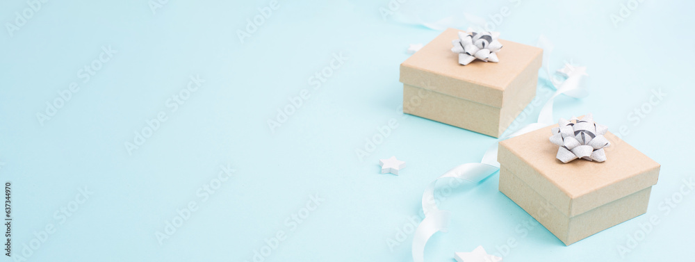 Fototapeta premium Christmas holiday greeting card with little gift boxes, stars and fir branches, blue background 