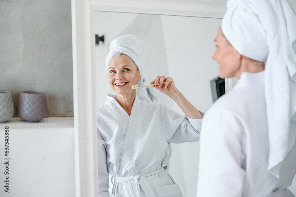 Reflection in mirror of woman with wide healthy smile